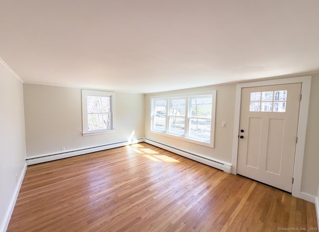 entrance foyer with baseboard heating, baseboards, and wood finished floors