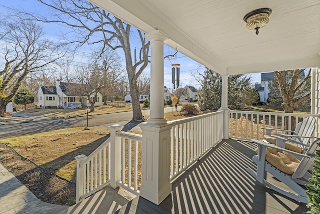 wooden deck featuring a residential view and covered porch