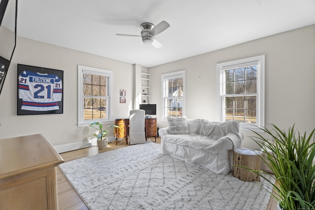 interior space featuring a healthy amount of sunlight, baseboards, ceiling fan, and wood finished floors