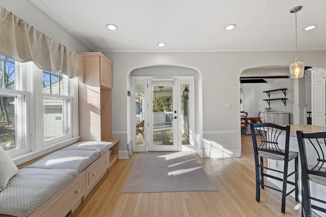 interior space with light wood-style flooring, recessed lighting, arched walkways, and a wealth of natural light