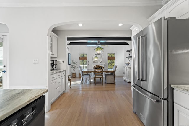 kitchen featuring arched walkways, high quality fridge, dishwasher, and white cabinetry