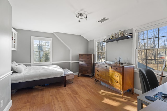 bedroom with lofted ceiling, baseboards, visible vents, and light wood-type flooring