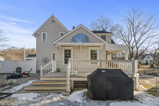 view of front facade with a wooden deck and fence