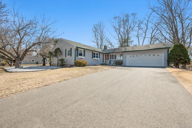 ranch-style house with aphalt driveway, a chimney, and a garage