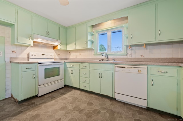 kitchen with tasteful backsplash, under cabinet range hood, light countertops, white appliances, and a sink