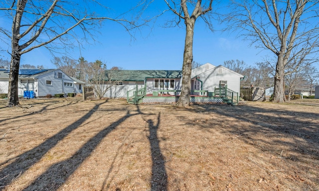 back of property with a wooden deck and fence