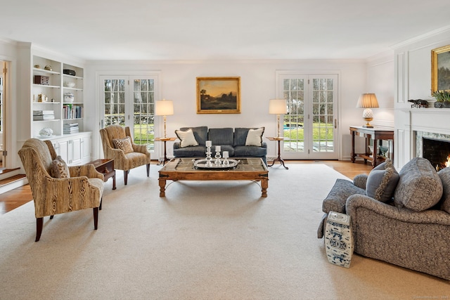 living room featuring a premium fireplace, ornamental molding, wood finished floors, and french doors