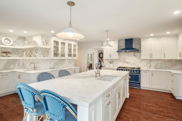 kitchen featuring a sink, wall chimney exhaust hood, dark wood finished floors, and double oven range