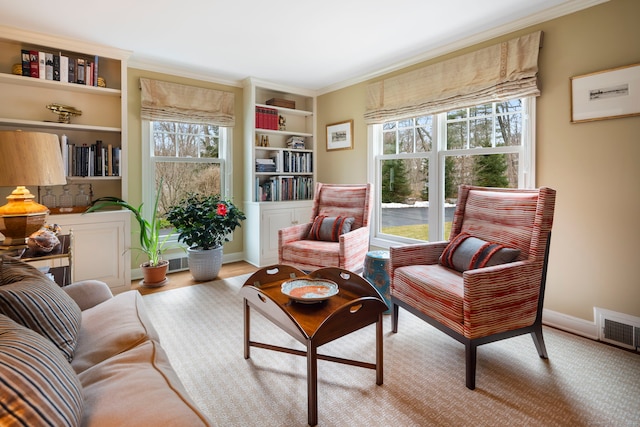 sitting room featuring a healthy amount of sunlight, visible vents, crown molding, and baseboards