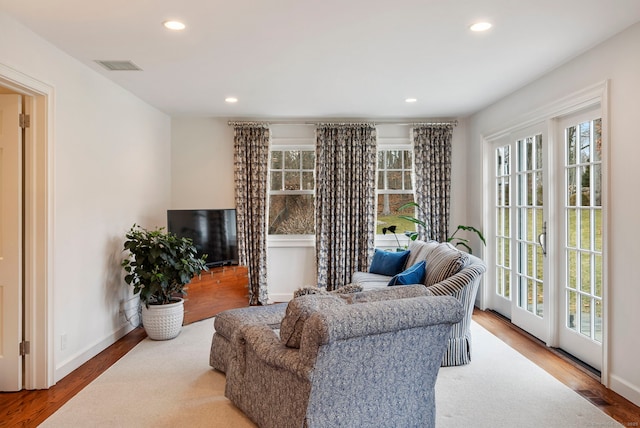 living area featuring a healthy amount of sunlight, wood finished floors, and recessed lighting