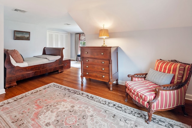 bedroom featuring visible vents, baseboards, and wood finished floors