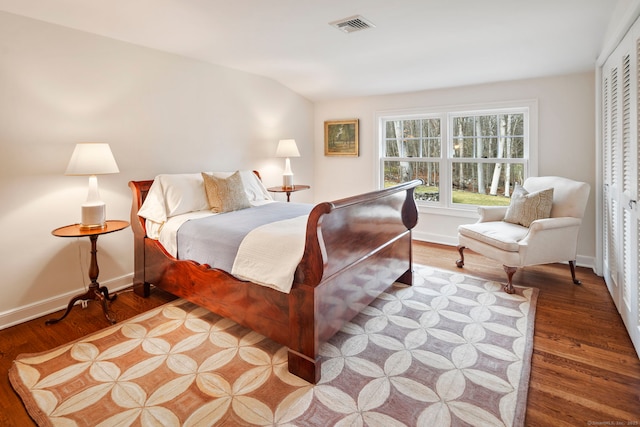 bedroom featuring wood finished floors, visible vents, and baseboards