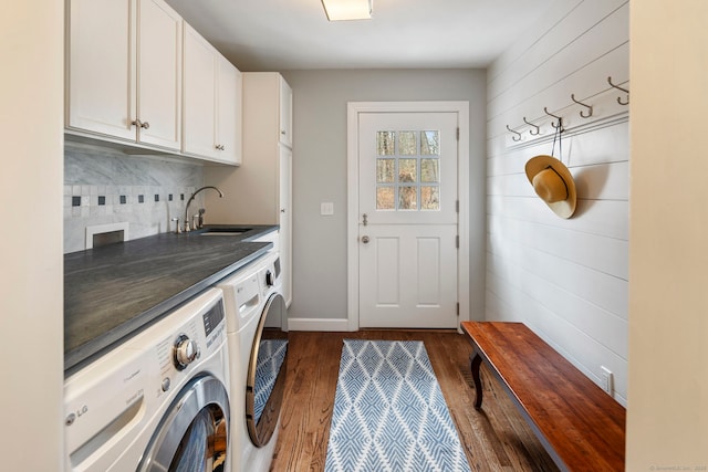 washroom with cabinet space, baseboards, dark wood-style floors, independent washer and dryer, and a sink