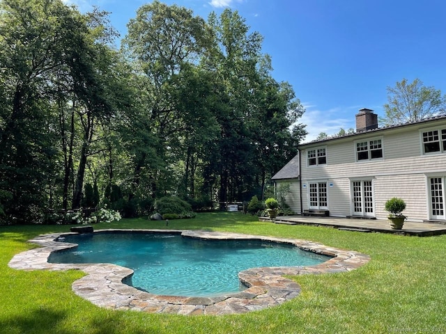 outdoor pool featuring french doors, a lawn, and a patio