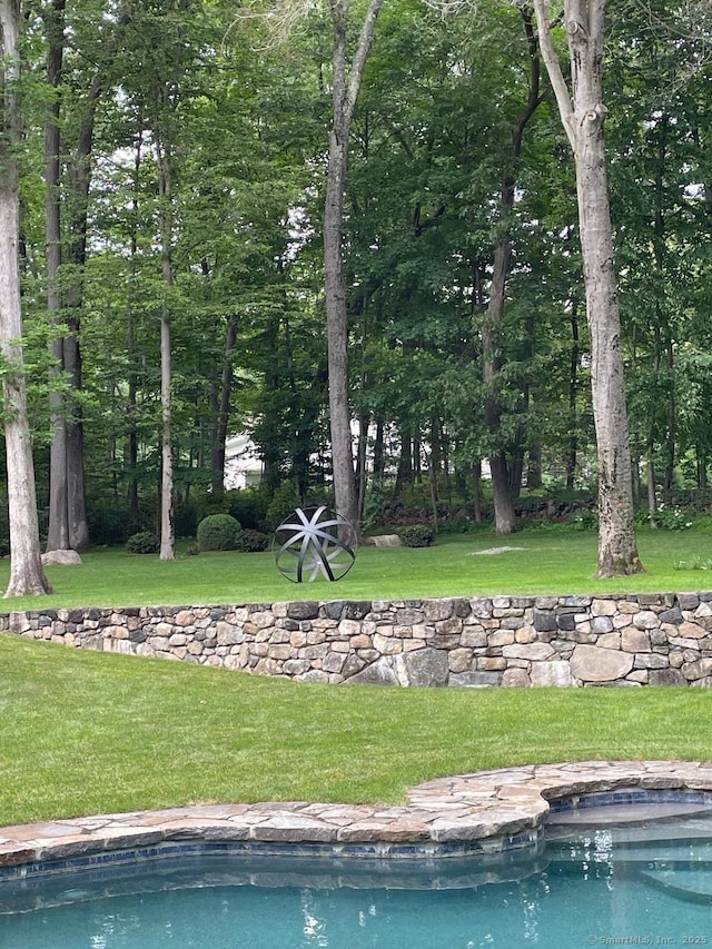 outdoor pool featuring a lawn