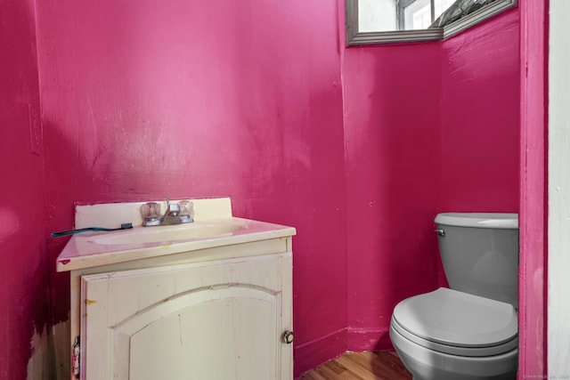 bathroom with vanity, toilet, and wood finished floors