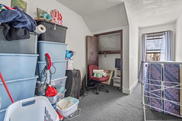 carpeted bedroom featuring a closet, vaulted ceiling, and a textured ceiling