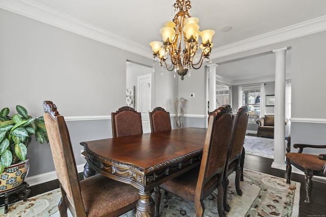 dining room featuring decorative columns, crown molding, and wood finished floors