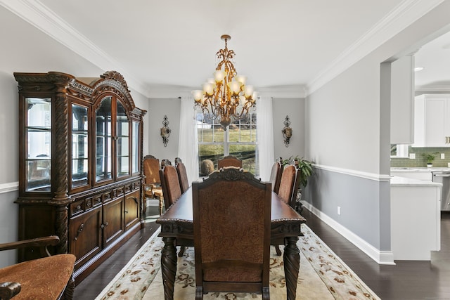 dining space with dark wood-style floors, crown molding, baseboards, and an inviting chandelier