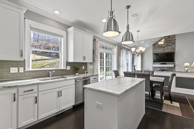 kitchen with dark wood-type flooring, open floor plan, a sink, and stainless steel dishwasher