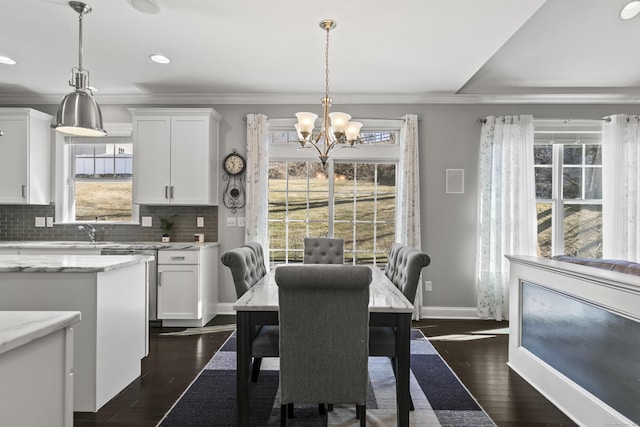 dining area with baseboards, a chandelier, dark wood finished floors, and ornamental molding