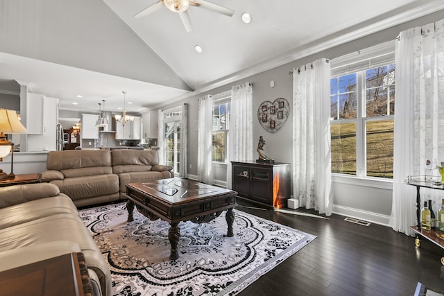 living area with ceiling fan with notable chandelier, dark wood-type flooring, visible vents, baseboards, and crown molding