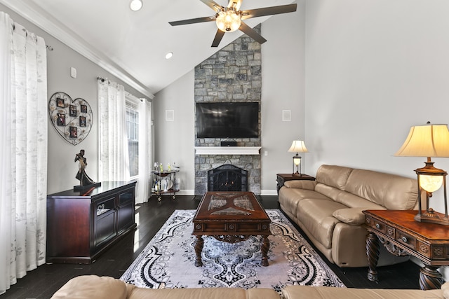 living area with dark wood-style floors, a ceiling fan, vaulted ceiling, a stone fireplace, and baseboards