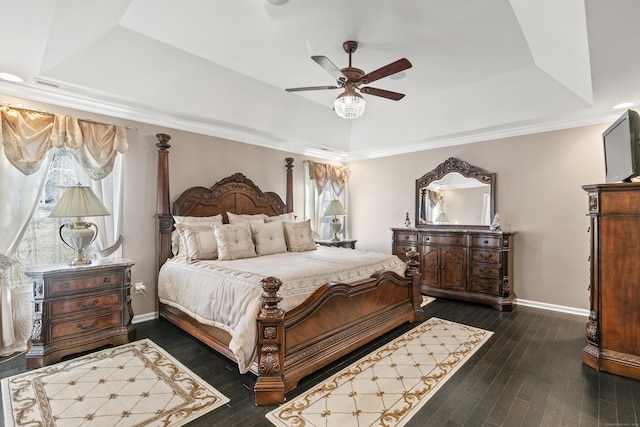 bedroom featuring baseboards, visible vents, ceiling fan, wood finished floors, and a tray ceiling