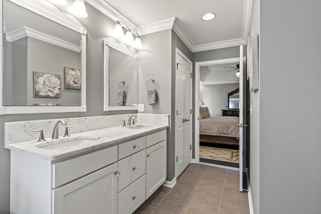 ensuite bathroom featuring double vanity, tile patterned flooring, crown molding, and a sink