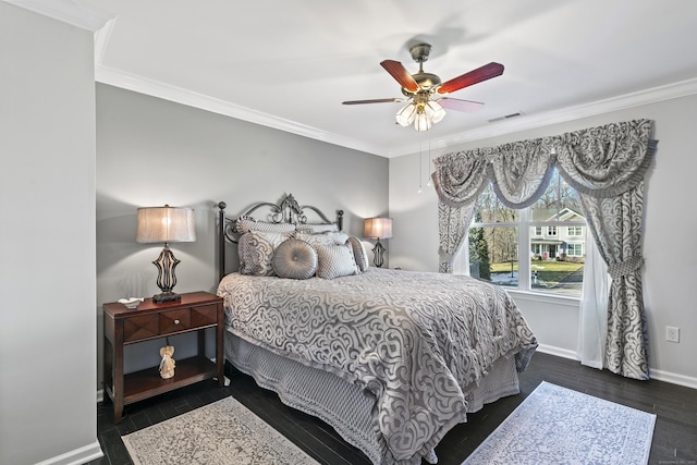 bedroom featuring dark wood-style floors, crown molding, visible vents, ceiling fan, and baseboards