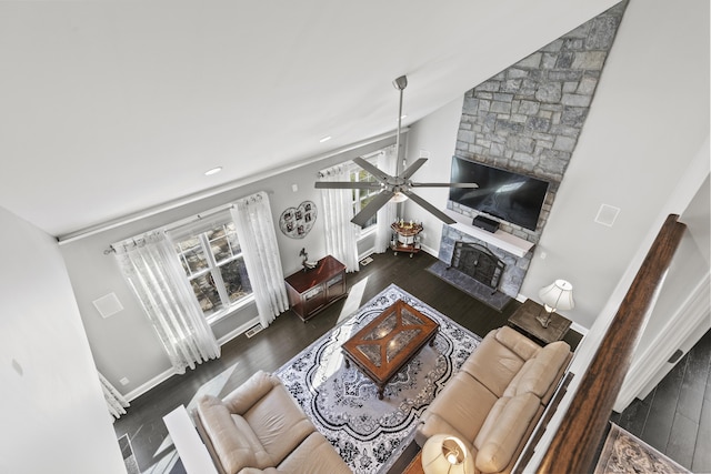 living area featuring ceiling fan, lofted ceiling, a fireplace, and wood finished floors