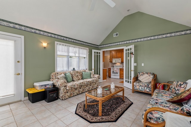 living area featuring light tile patterned floors, ceiling fan, visible vents, and high vaulted ceiling