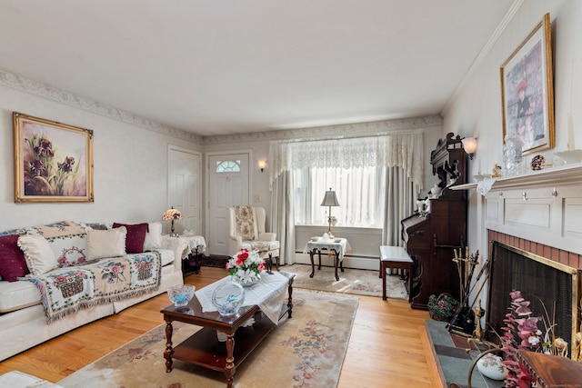 living room with a brick fireplace, baseboard heating, and wood finished floors