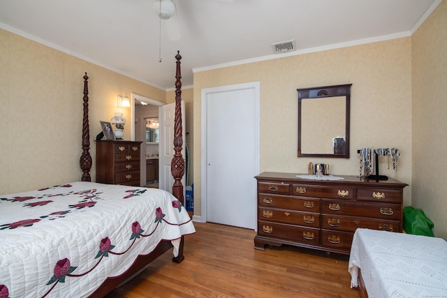 bedroom featuring visible vents, wood finished floors, and ornamental molding