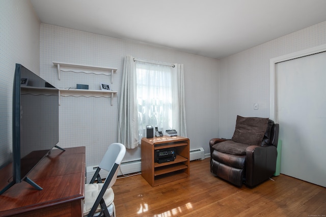 home office featuring a baseboard heating unit and wood finished floors