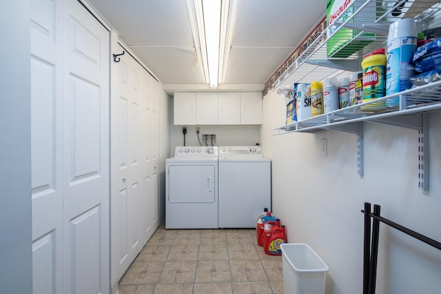 clothes washing area with washing machine and dryer and cabinet space