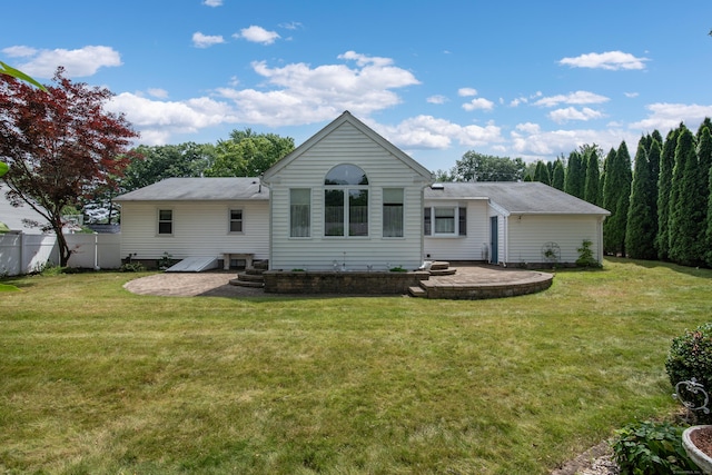 rear view of house featuring a patio, a lawn, and fence