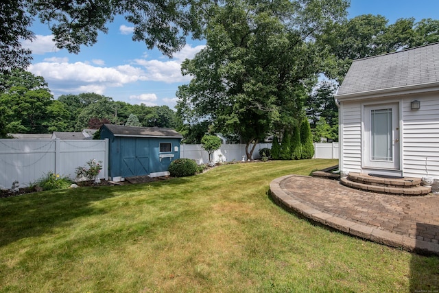 view of yard with a storage shed, a fenced backyard, and an outdoor structure