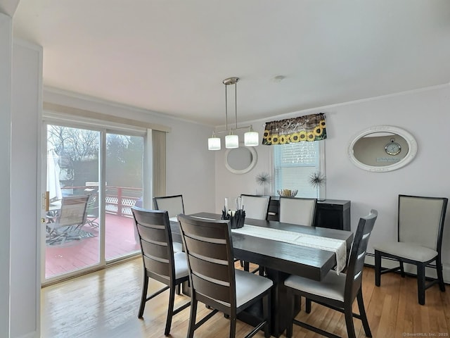 dining area with ornamental molding, light wood-type flooring, and plenty of natural light