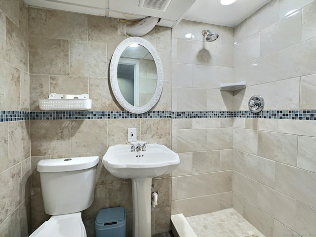 bathroom featuring toilet, visible vents, and a tile shower