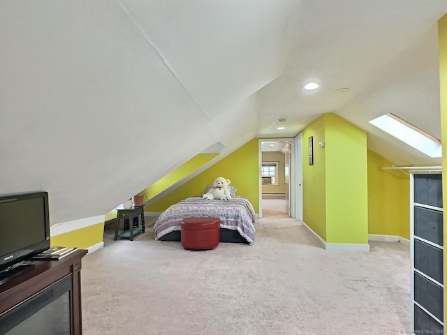 bedroom featuring lofted ceiling with skylight, carpet floors, and baseboards