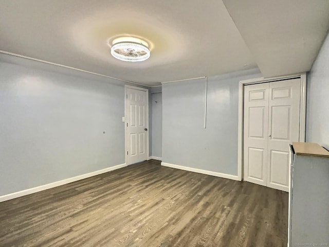 below grade area with dark wood-type flooring and baseboards