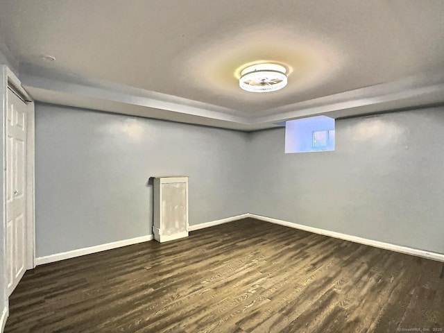 below grade area featuring dark wood finished floors and baseboards