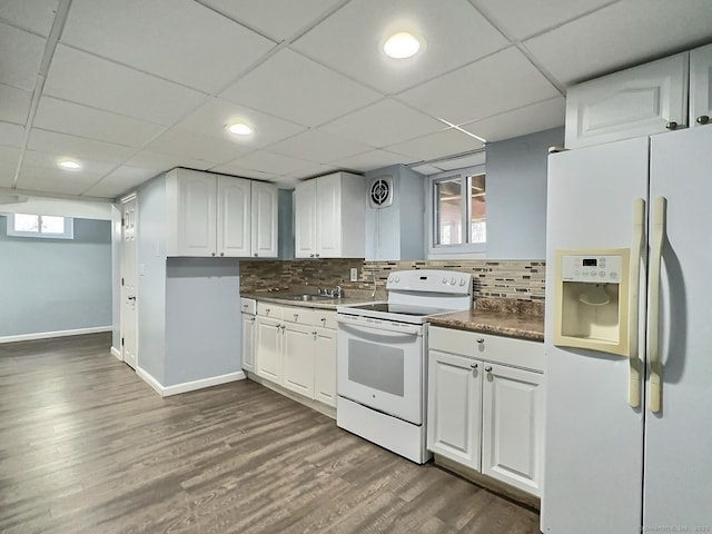 kitchen with white appliances, visible vents, decorative backsplash, dark countertops, and dark wood-style floors