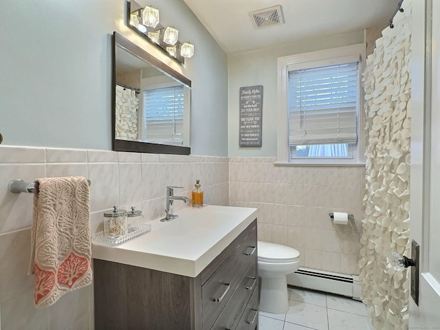 full bath with visible vents, toilet, baseboard heating, vanity, and tile walls