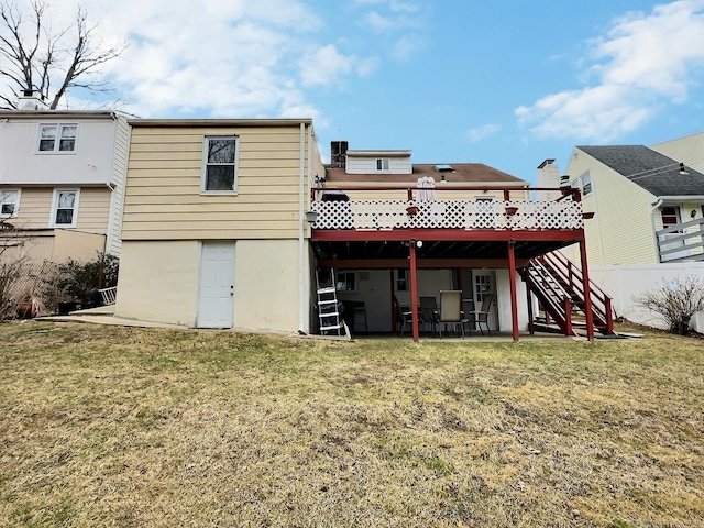 rear view of property with stairs, a deck, and a lawn