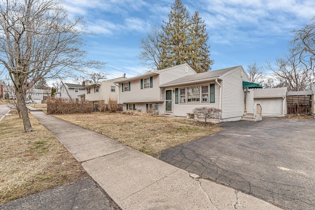 tri-level home featuring entry steps and a front yard