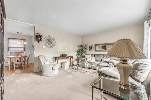 carpeted living room featuring a chandelier