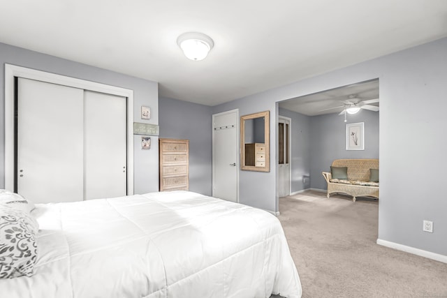 bedroom featuring light carpet, a closet, and baseboards