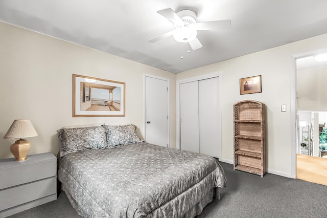 bedroom with a ceiling fan, baseboards, dark carpet, and a closet